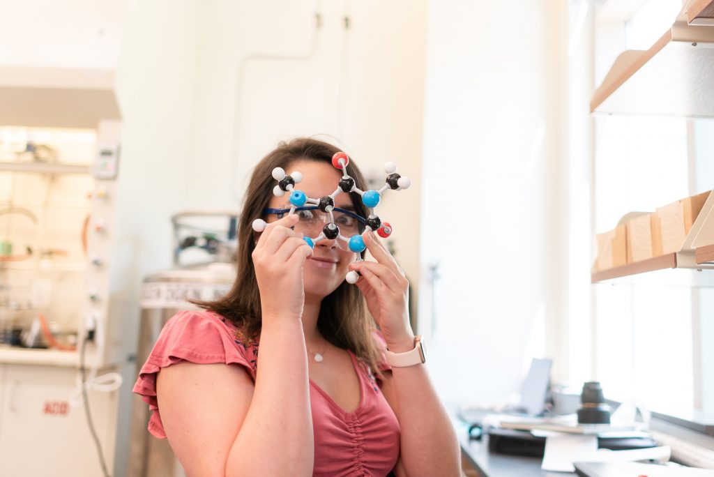 Alexa looking through the rings of a plastic molecule model